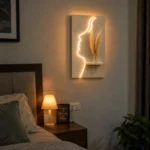That's a beautiful piece — a glowing face silhouette LED wall art with a mini shelf and pampas grass. Very on-trend for home decor! - Image 2